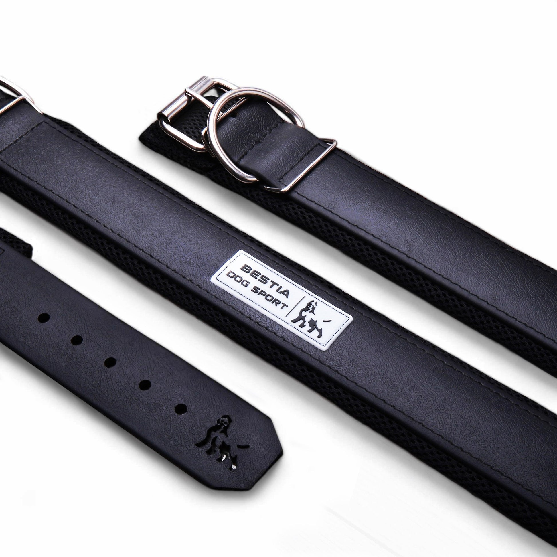 Black leather dog collar with metal buckle and BESTIA DOG SPORT label, laid flat on white background.