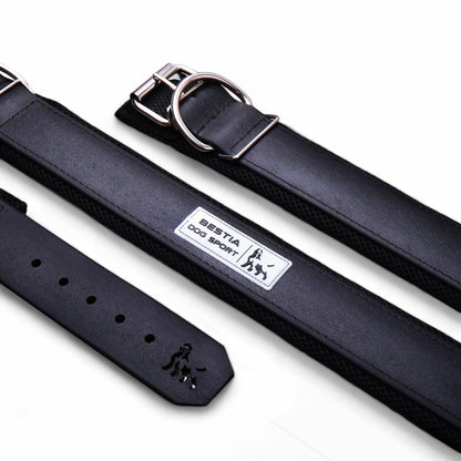 Black leather dog collar with metal buckle and BESTIA DOG SPORT label, laid flat on white background.