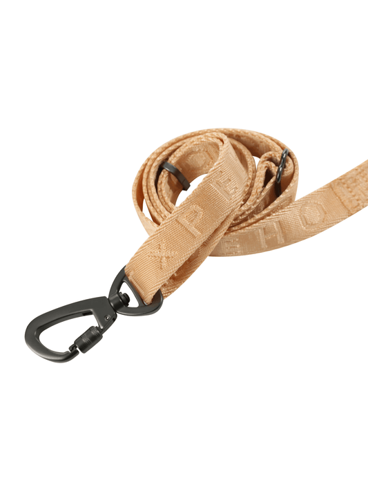 Tan woven leash with black metal clasp, coiled against white background.