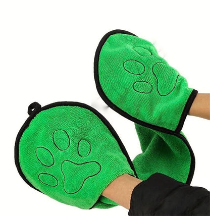 Green microfiber pet grooming mitts with paw print design on hands.